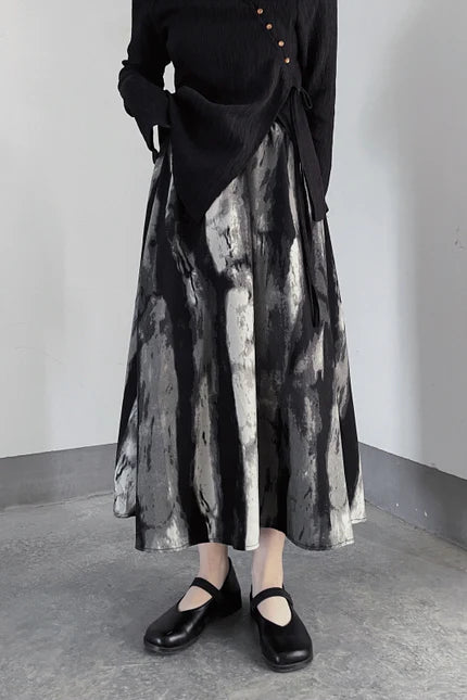 Monochrome artistic long skirt with abstract pattern from Belle Vestige, featuring a flowing A-line silhouette perfect for adding texture and vintage style to any look.